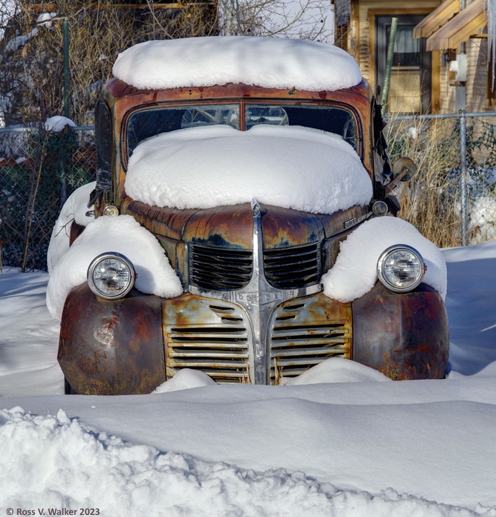 A rusty Dodge truck is parked for the winter on a side street in Montpelier, Idaho